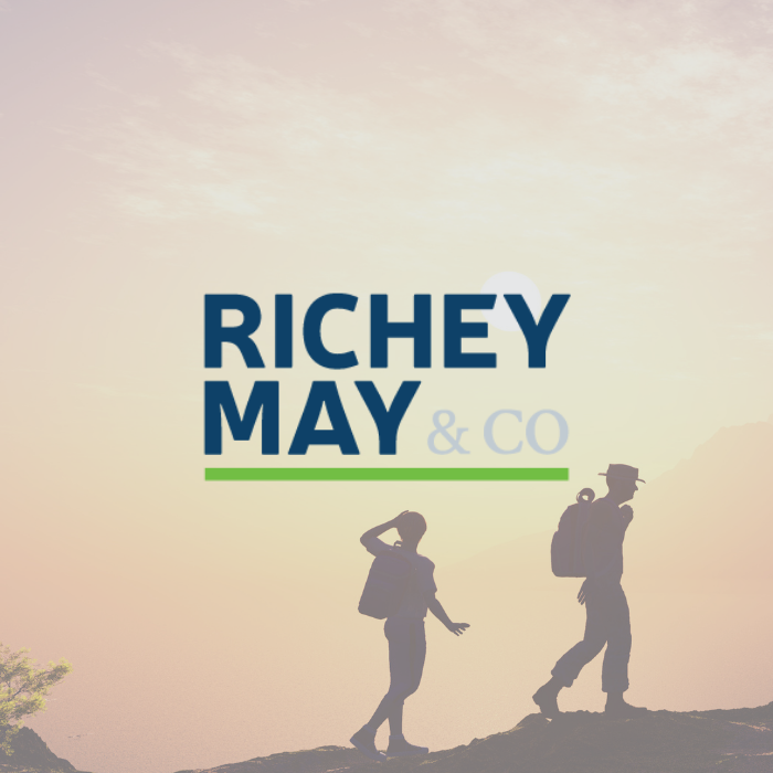 Richey May & Co title with background of two people hiking during sunset