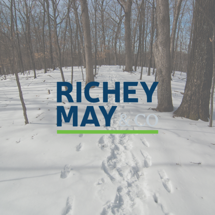 Richey May & Co title with background of a footprints in the snow covered woods